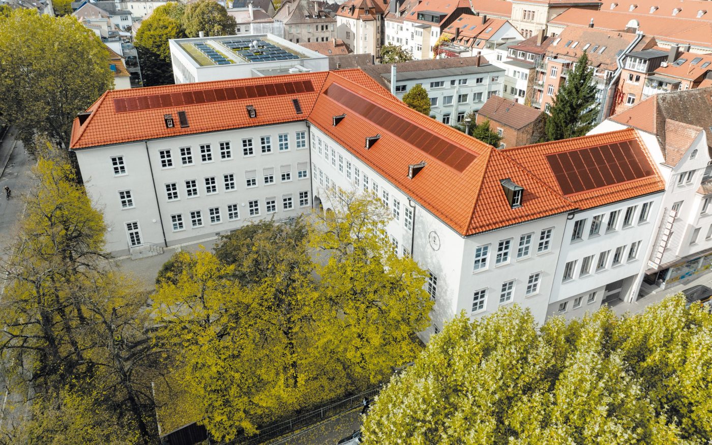 Budynek z dachem z dachówki i czerwonymi panelami fotowoltaicznymi X-Frame